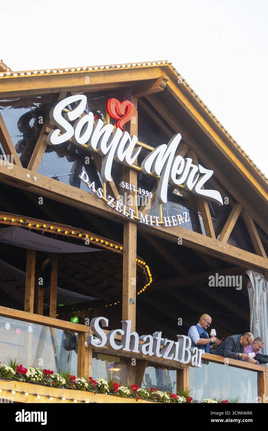 Balcone in legno con scritta in atmosfera serale e illuminazione festosa, Cannstatter Wasen folk festival, Stoccarda, Germania Foto Stock