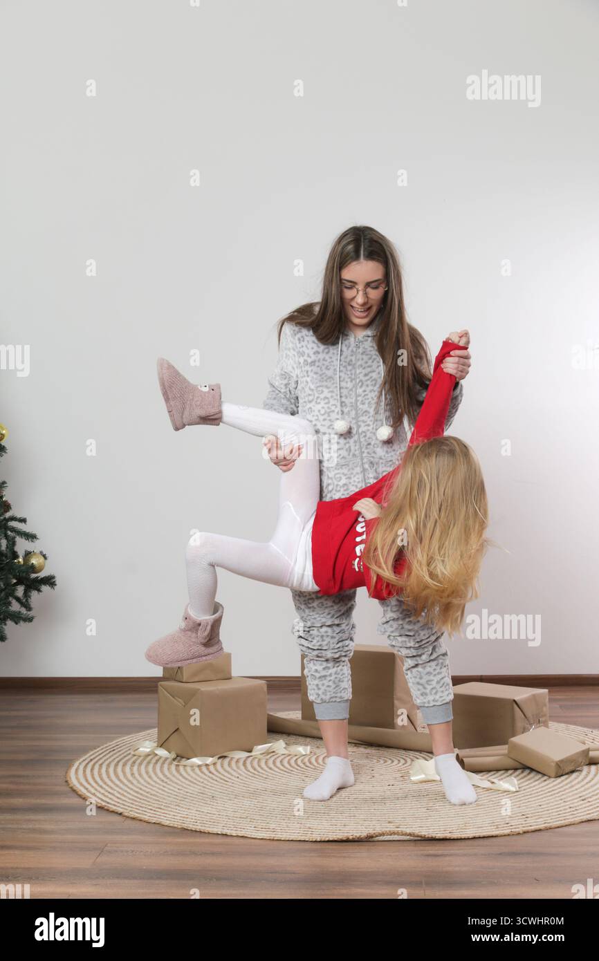 Sorelle che si divertono con i preparativi natalizi di Pippo - allegra scena per le vacanze in famiglia Foto Stock