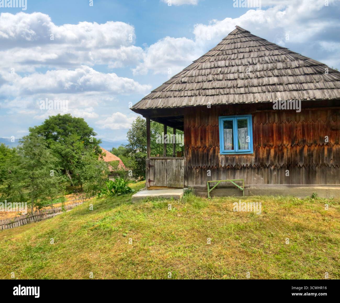 Cortile tradizionali case in legno con tetto a tegole in Transilvania, alberi, paesaggio sulle montagne della Romania, Foto Stock