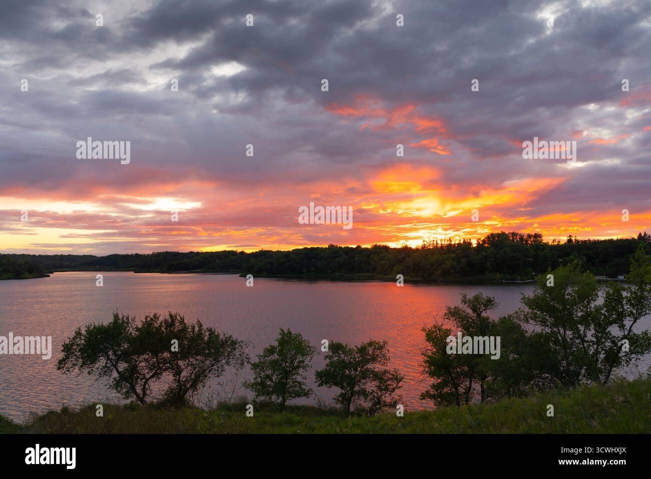 Nuvole e colori spettacolari al tramonto sul lago Minnewasta, Morden, Manitoba, Canada. Foto Stock