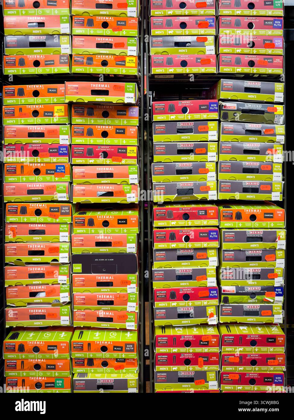 File di scatole di scarpe colorate impilate sullo scaffale di un negozio, che espone una varietà di marchi e dimensioni.motivo astratto Foto Stock