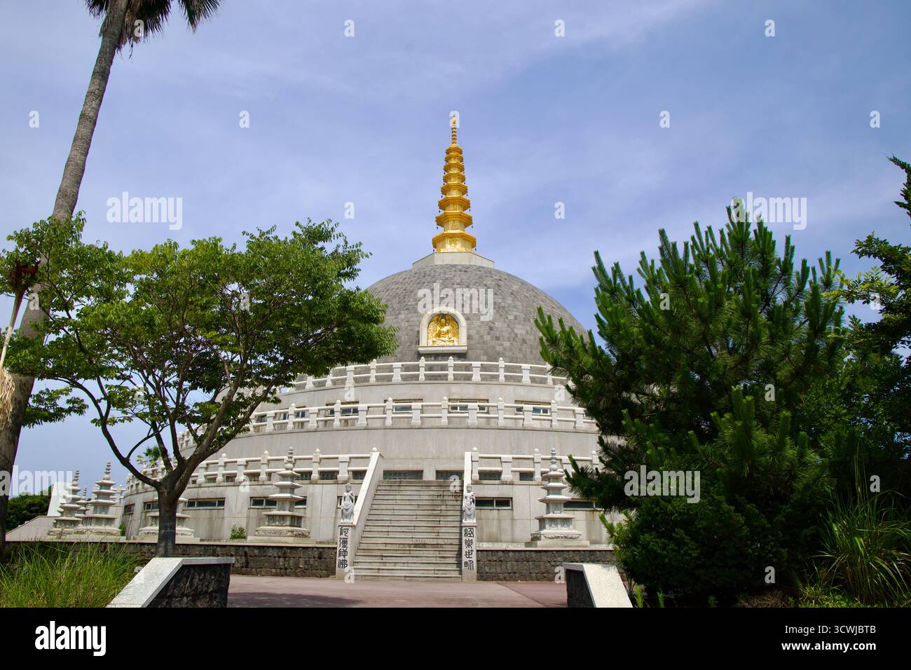 Ampi gradini conducono alla terrazza del Buddha Sharira Stupa per la pace e l'unificazione del mondo nella città di Jeju, con statue, lanterne di pietra e stratificate Foto Stock