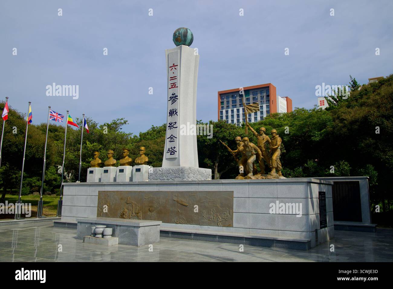 Il monumento alla guerra di Corea a Sinsan Park presenta un alto pilastro inciso, rilievi in bronzo e statue di soldati in marcia con bandiere alleate nelle vicinanze. Foto Stock