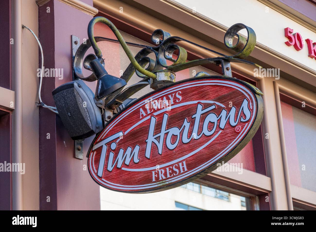 Saint John, NB - CA - 30 settembre 2025 foto ravvicinata di un cartello ovale rosso e bianco di Tim Hortons appeso all'esterno di un edificio con il numero 501 ab Foto Stock