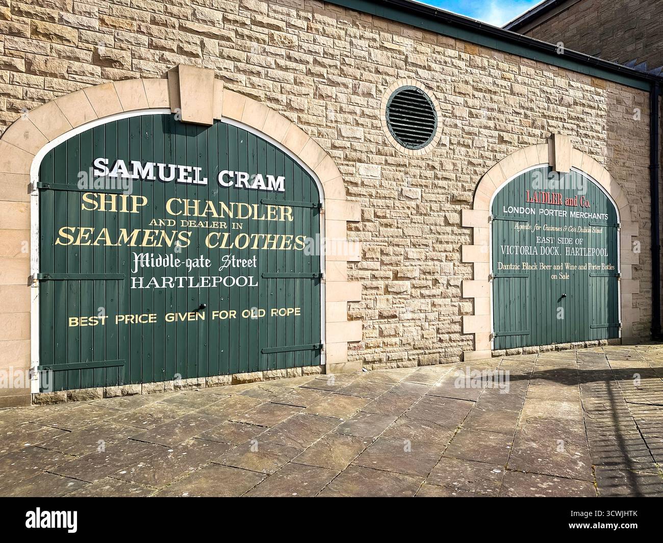 Porte di magazzino vintage con pubblicità dipinte per una nave chandler e un negozio di abbigliamento per marinai situato ad Hartlepool - Immagine stock catturata con smartphone