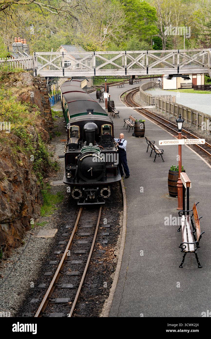 Locomotiva a vapore d'epoca sulla piattaforma della stazione ferroviaria storica con passerella pedonale Foto Stock