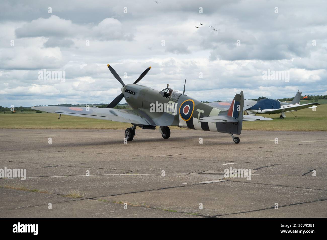 Supermarine Spitfire sulla pista all'aeroporto di Duxford con il cerchio della RAF e le strisce di invasione Foto Stock