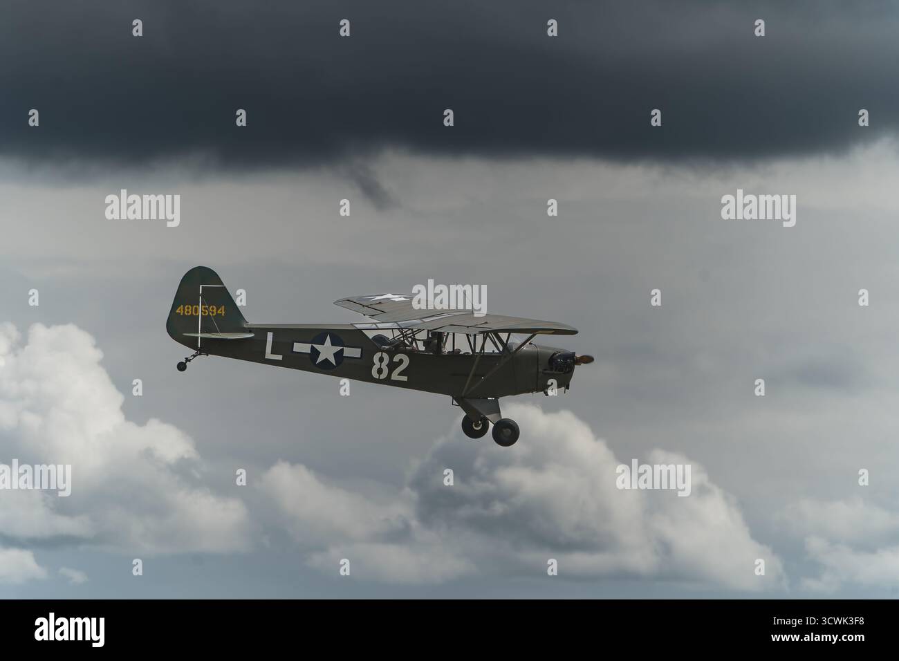Aereo di collegamento L-4 Grasshopper dell'esercito STATUNITENSE che vola contro il cielo nuvoloso Foto Stock