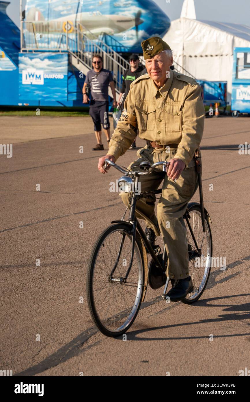Reattore in tempo di guerra in uniforme militare con bicicletta d'epoca all'Imperial War Museum di Duxford Foto Stock