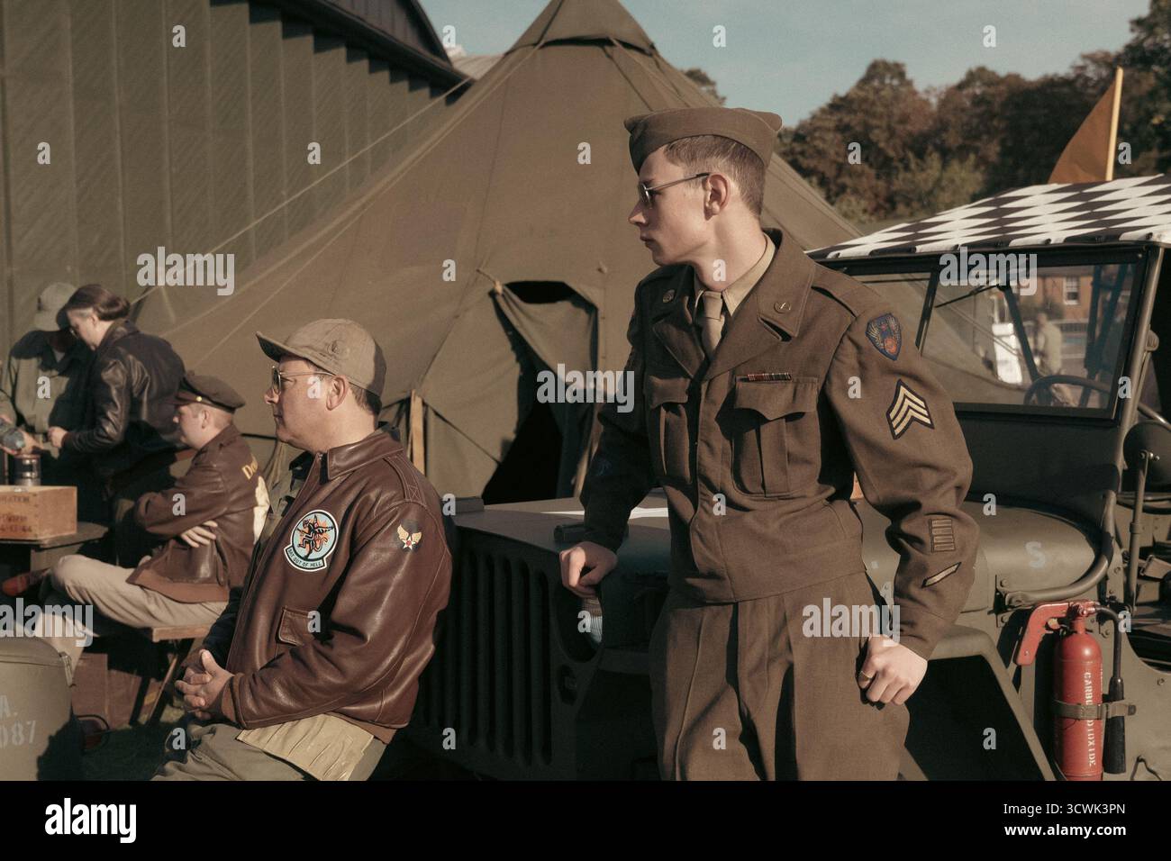Militari americani della seconda guerra mondiale in uniforme d'epoca al campo militare con tende e veicoli Foto Stock