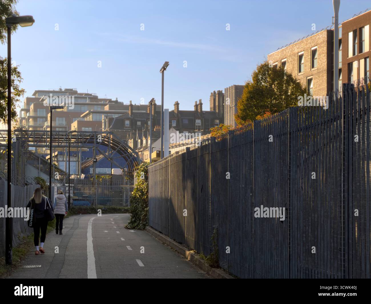 Due donne passano davanti a un cantiere vicino a Blackburn Road, West Hampstead, Londra Foto Stock