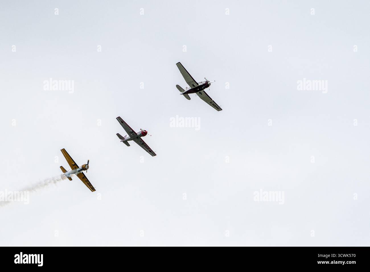 Tre aerei d'epoca che volano in formazione contro il cielo nuvoloso al Duxford Airshow Foto Stock