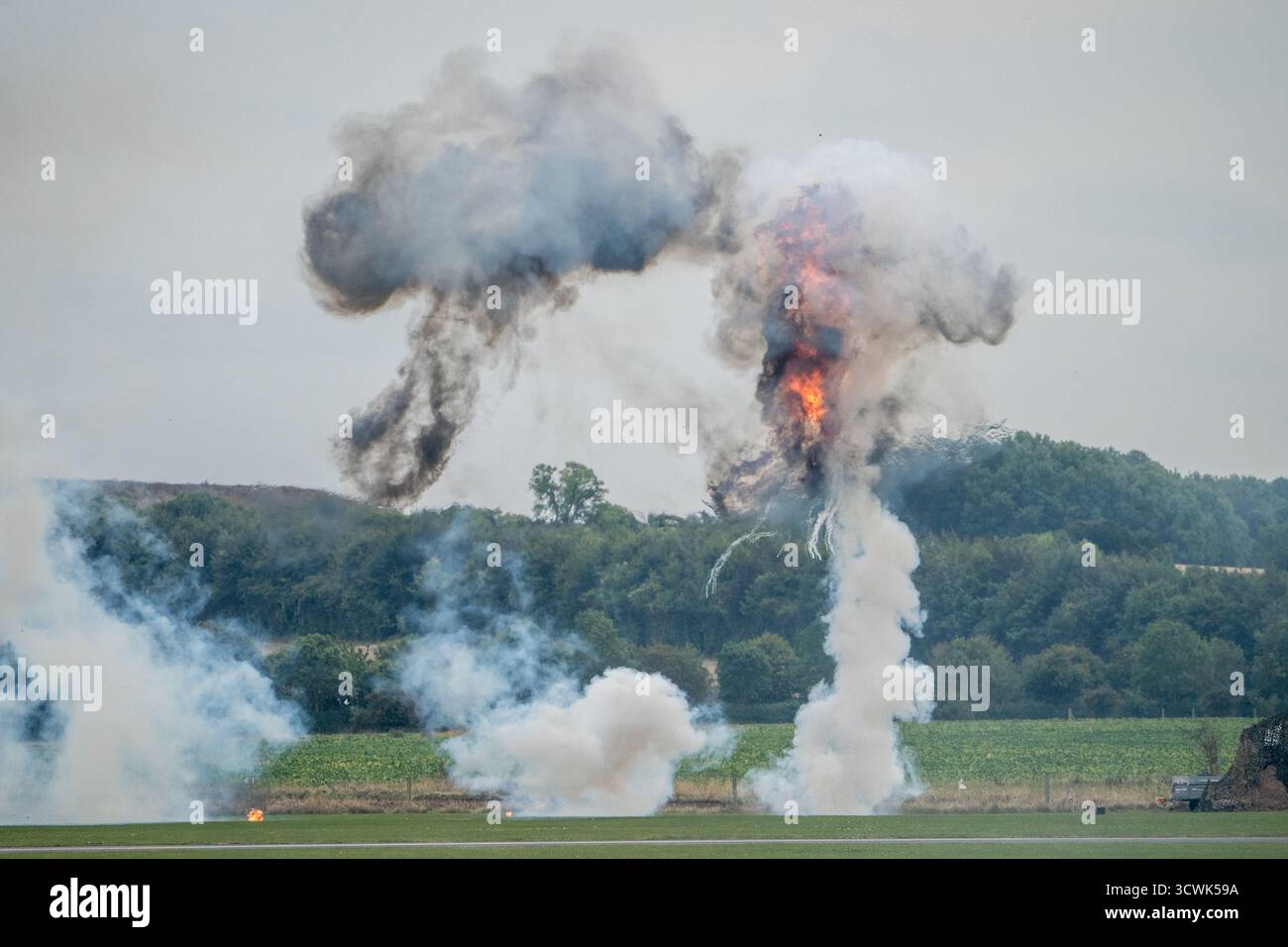 Spettacolare esposizione pirotecnica militare con esplosioni e fumo all'aeroporto Foto Stock