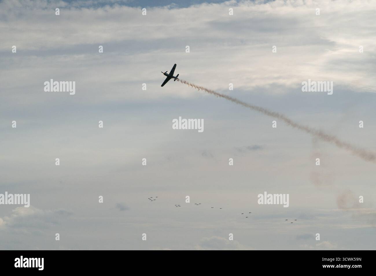 Aerei acrobatici che eseguono manovre spettacolari con sentieri di fumo contro il cielo nuvoloso Foto Stock