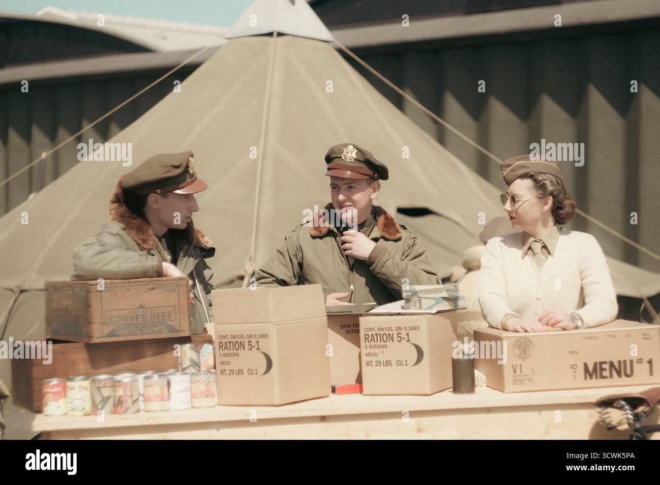 Personale militare della seconda guerra mondiale nella cucina da campo con scatole di razione e tenda in tela Foto Stock