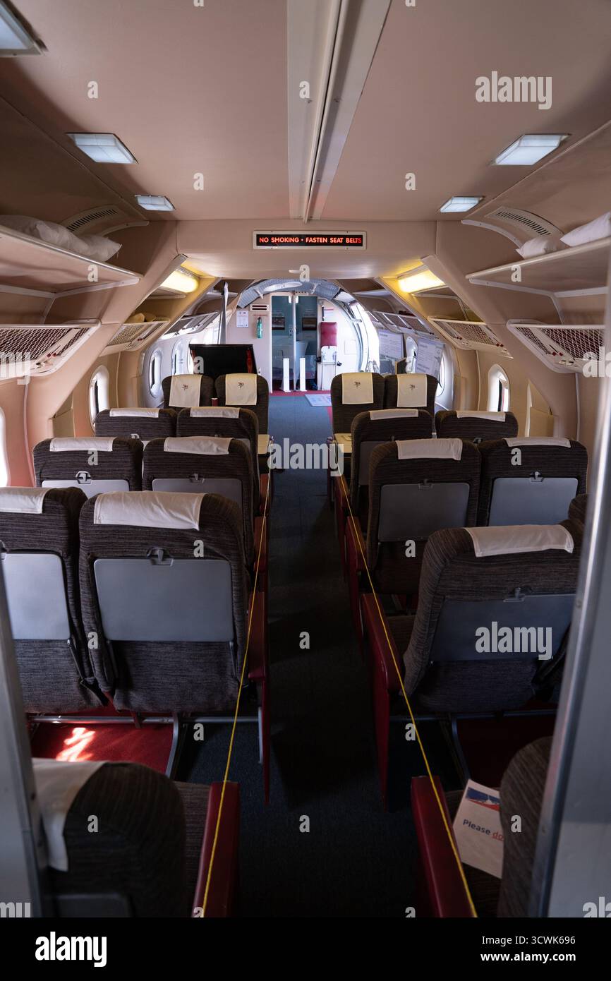 Vista interna della cabina passeggeri dell'aeromobile d'epoca con file di sedili e corridoio Foto Stock