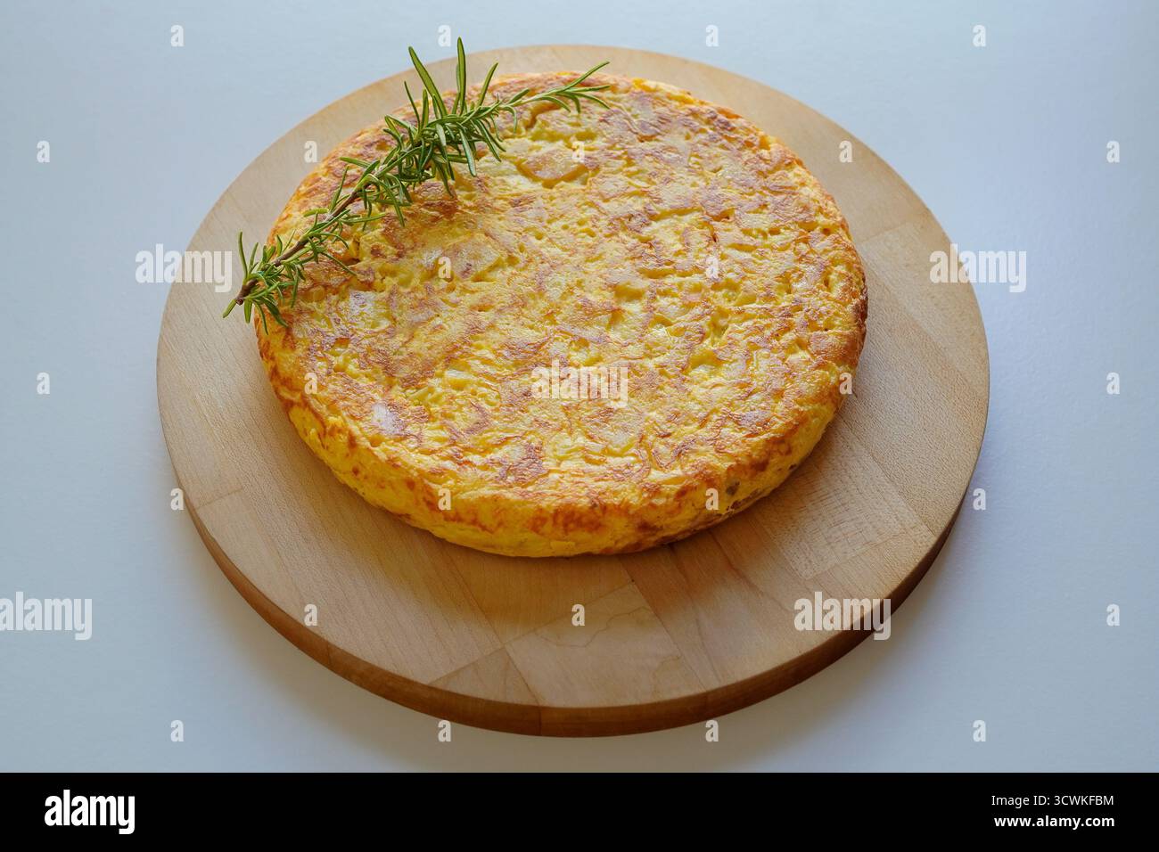 Omelette spagnole fatte in casa (tortilla de patatas) poste su un piatto di legno Foto Stock
