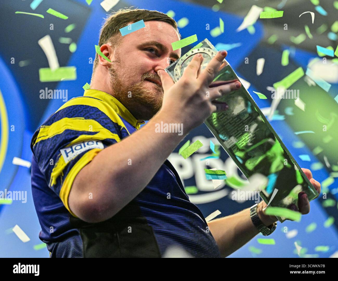 Mattioli Arena, Leicester Leicestershire, Regno Unito. 12 ottobre 2025. 2025 PDC Boyle Sports World Grand Prix Darts Final Night; Luke Littler detiene il trofeo dopo la sua vittoria su Luke Humphries nella finale del Boyle Sports World Grand Prix man mano che i coriandoli calano Credit: Action Plus Sports/Alamy Live News Foto Stock