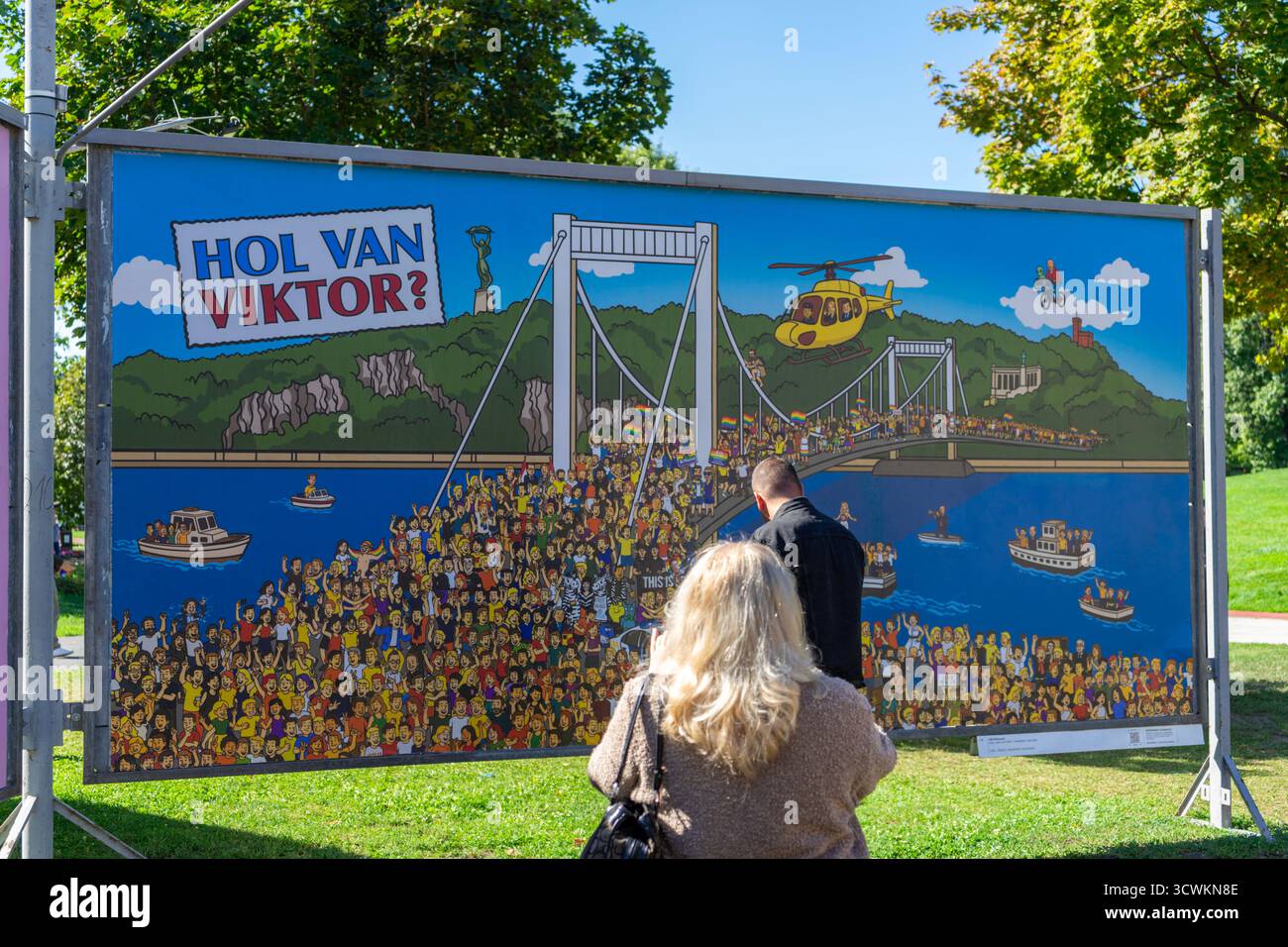 Opera d’arte alla mostra di poster ARC a Budapest che raffigura un tema Pride con la frase «Hol van Viktor?» E una sfilata di massa sul Danubio. Foto Stock