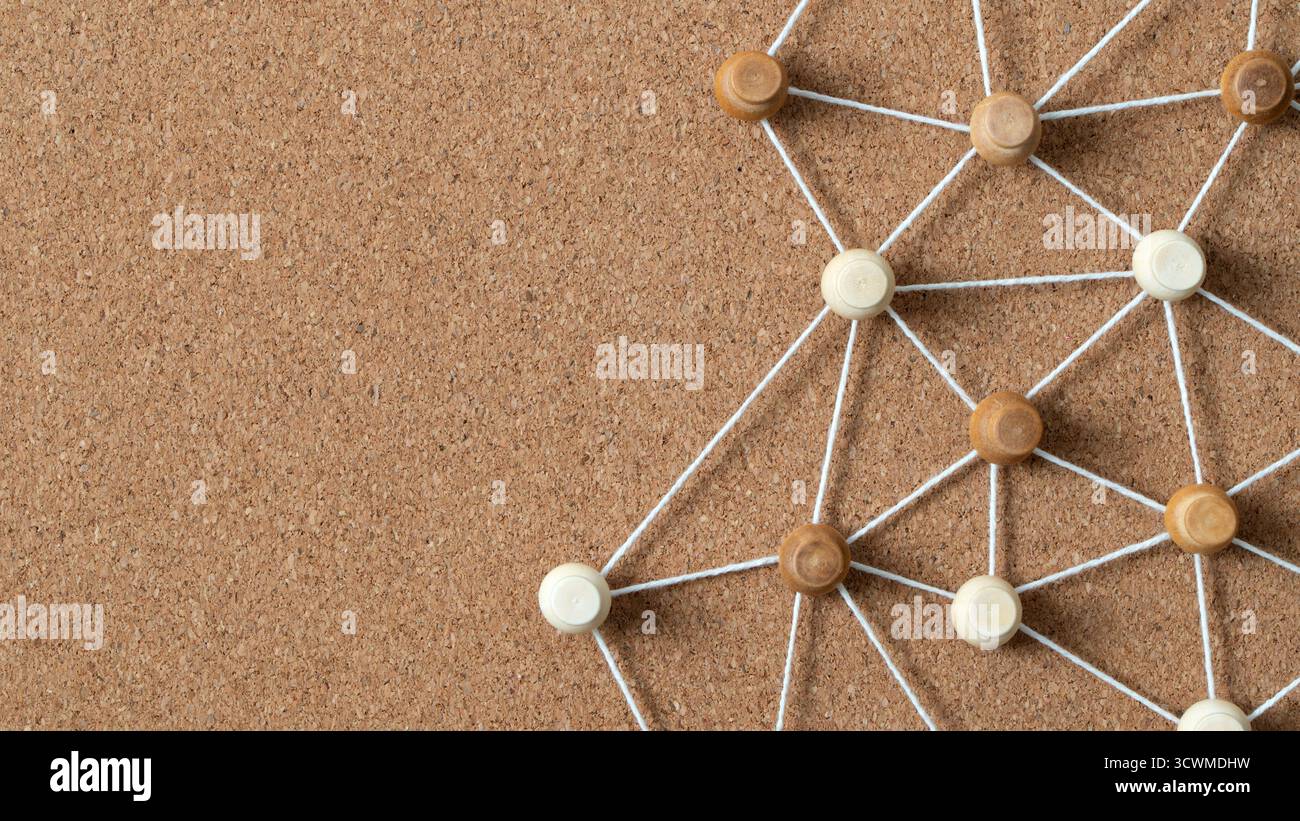 Pulsanti in legno collegati da una corda bianca su un cordoncino, che illustrano un social network, un collegamento tra persone o una mappa concettuale. Foto Stock