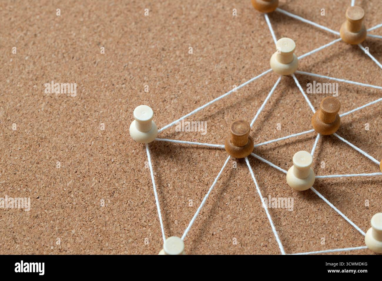 Pulsanti in legno collegati da una corda bianca su un cordoncino, che illustrano un social network, un collegamento tra persone o una mappa concettuale. Foto Stock