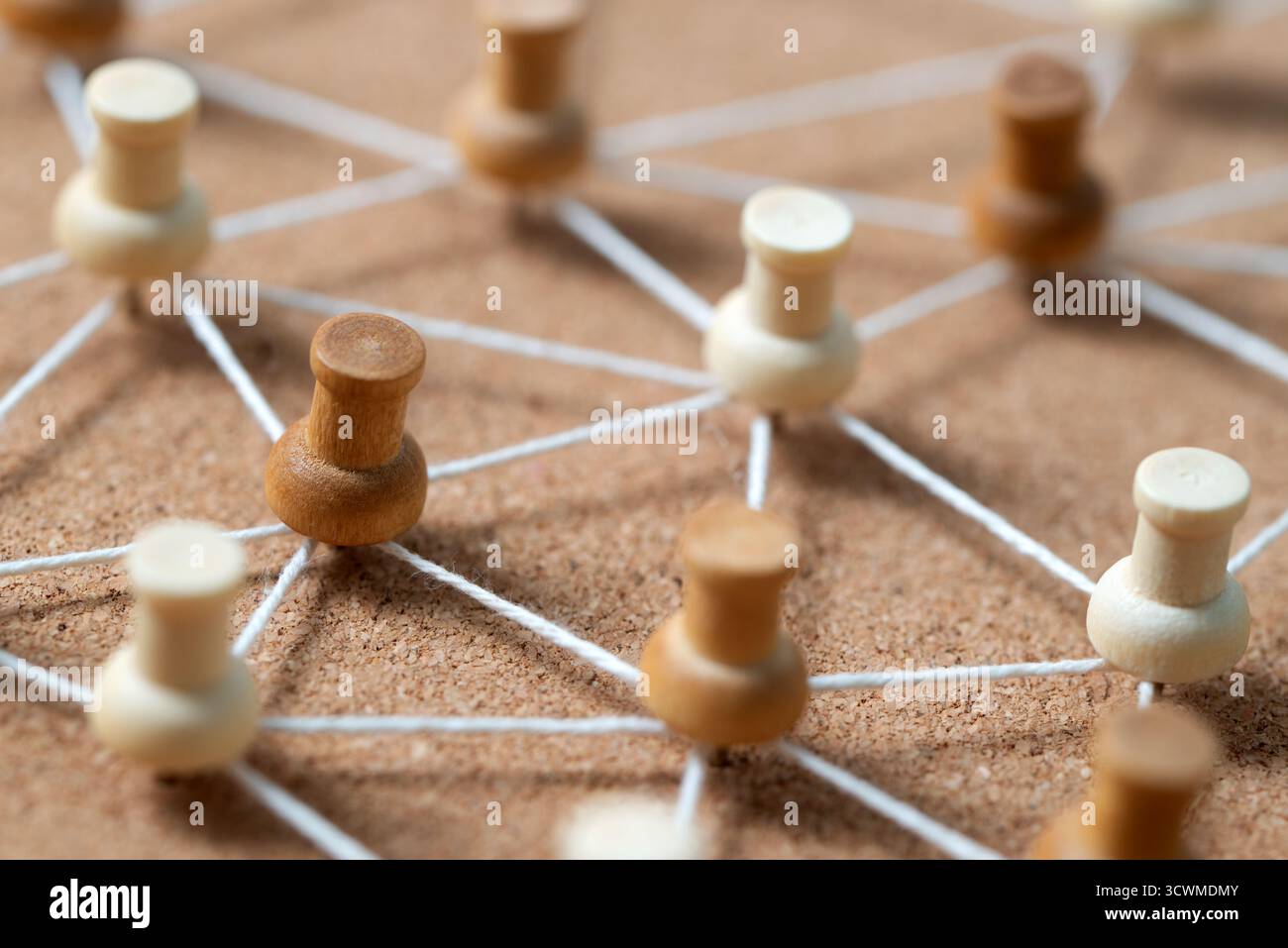 Pulsanti in legno collegati da una corda bianca su un cordoncino, che illustrano un social network, un collegamento tra persone o una mappa concettuale. Foto Stock