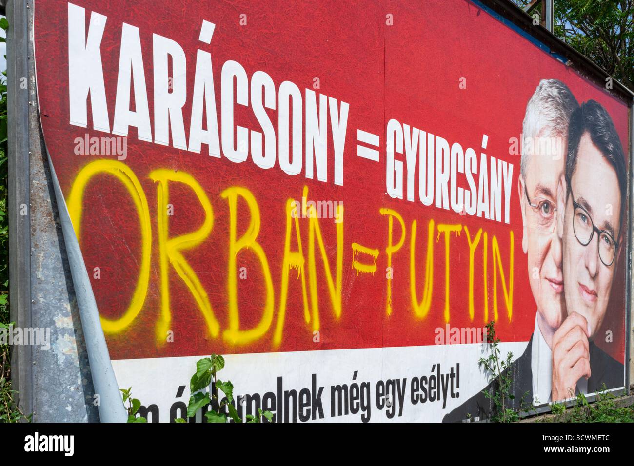 Sfigurato cartellone politico ungherese che collega le figure dell'opposizione, con graffiti che confrontano il primo ministro Orbán con Vladimir Putin. Foto Stock