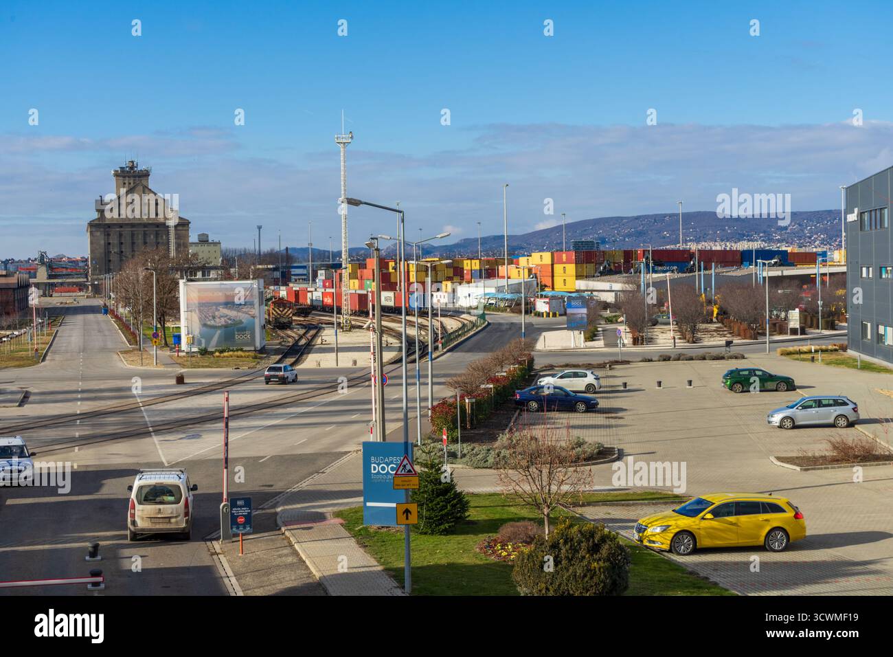 Il Csepel Freeport di Budapest, Ungheria, mostra binari ferroviari, container ed edifici industriali sotto i cieli invernali. Foto Stock