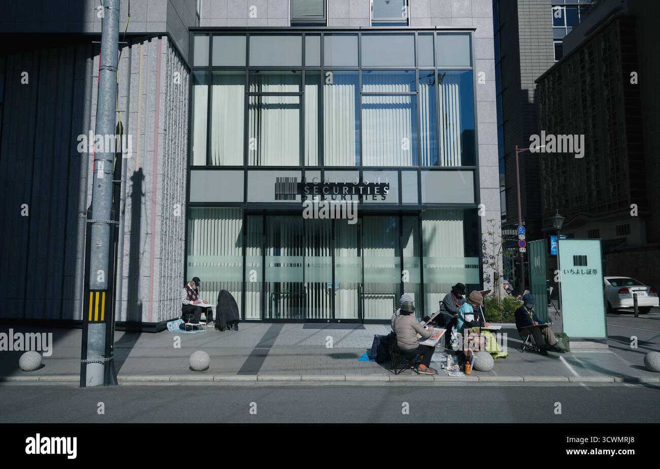 Un gruppo di artisti disegna all'aperto di fronte ad un moderno edificio di sicurezza a Osaka Foto Stock