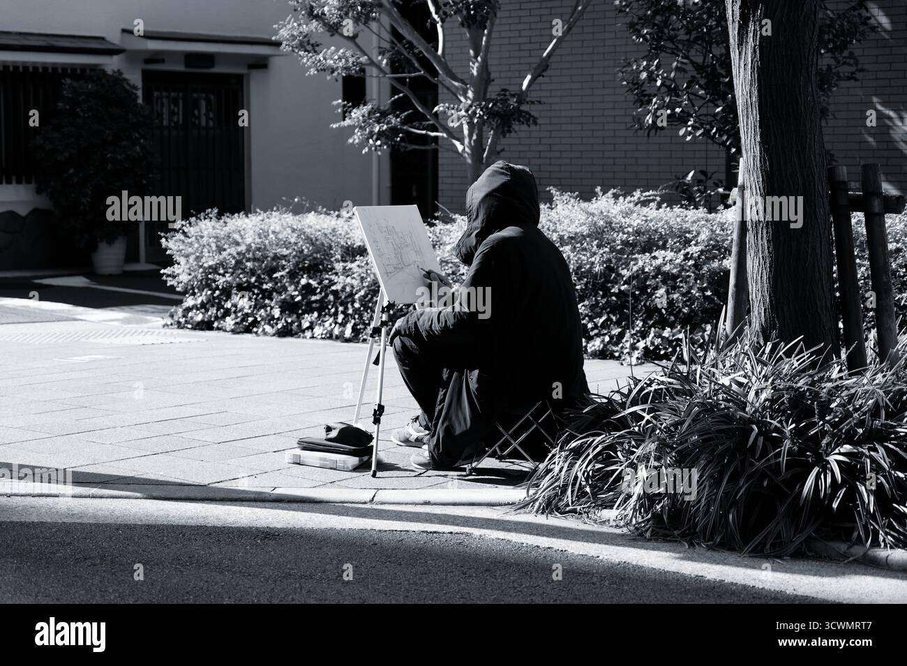 Un artista di strada nel Chuo Ward di Osaka disegna tranquillamente alla luce del sole invernale Foto Stock