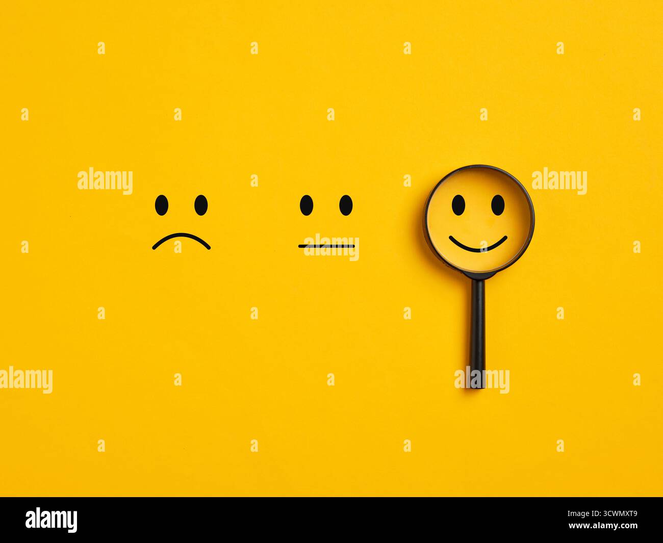 Lente d'ingrandimento focalizzata su un emoji positivo tra opzioni negative e neutrali, sottolineando un buon servizio clienti, una valutazione positiva e la soddisfazione Foto Stock