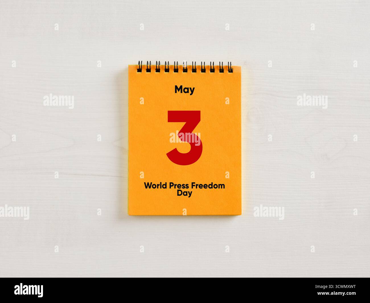 Calendario desktop arancione che evidenzia il 3 maggio, giornata mondiale della libertà di stampa, che promuove la consapevolezza dei principi fondamentali Foto Stock