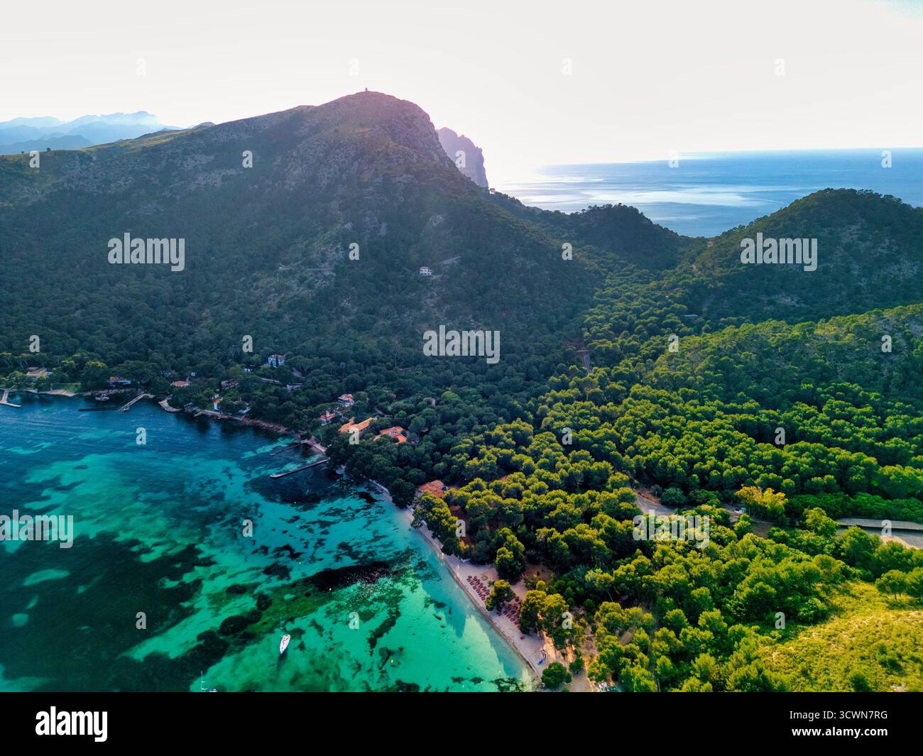 Vista aerea delle acque turchesi che incontrano le lussureggianti foreste verdi di Cala Ratjada, creando un contrasto incredibile con la costa frastagliata, Cala Ratjada, Foto Stock