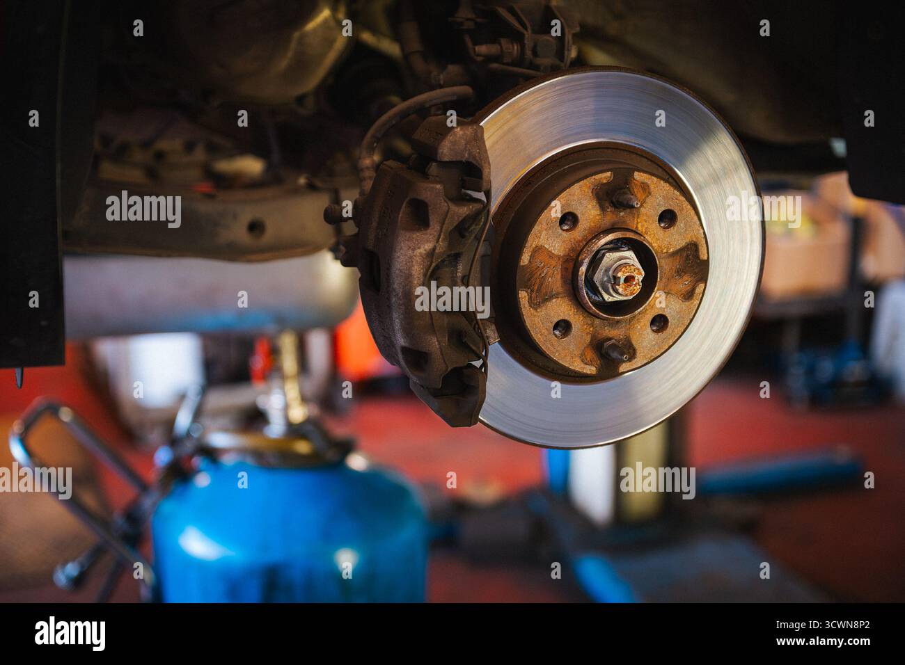 Il freno a disco e la pinza dell'auto vengono sottoposti a manutenzione in un'officina automobilistica Foto Stock