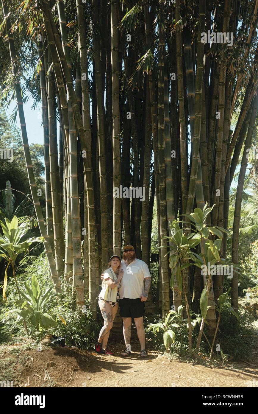 La coppia sta insieme sotto il torreggiante boschetto di bambù a Maui Foto Stock