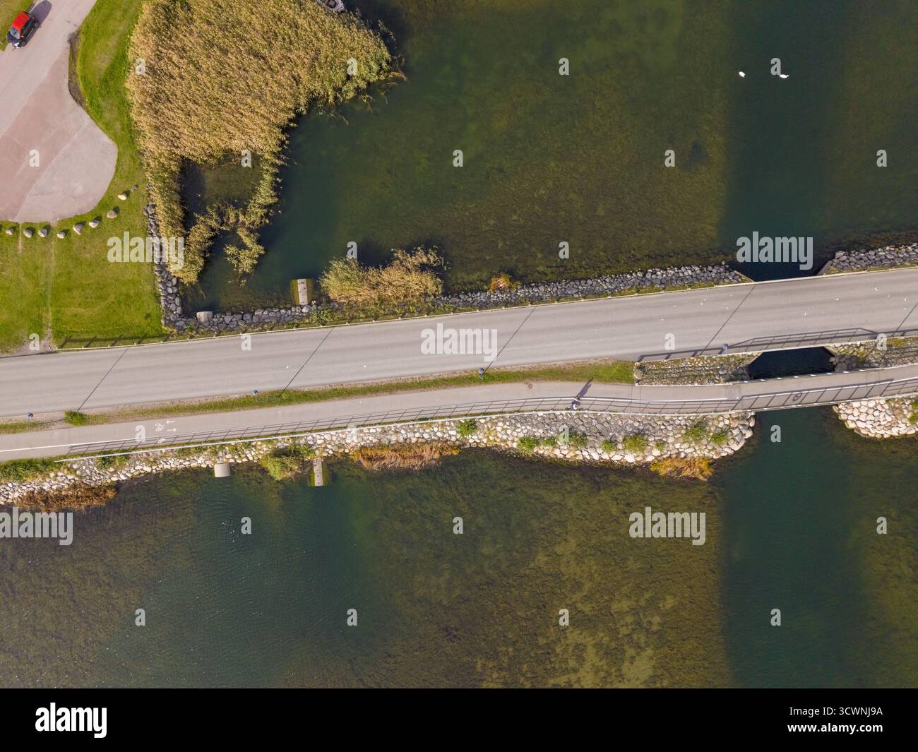 Vista aerea di un ponte che taglia l'acqua, contrastando l'acqua serena con le linee dure della struttura artificiale, Kalmar, Kalmar County, S. Foto Stock