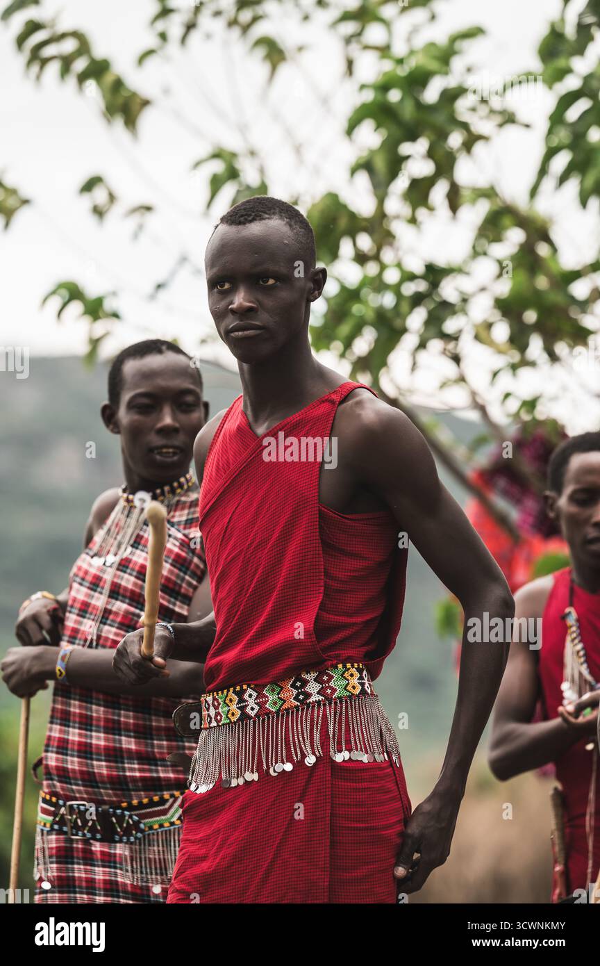Giovani uomini in tradizionale abbigliamento rosso con cinture in rilievo Masai Foto Stock