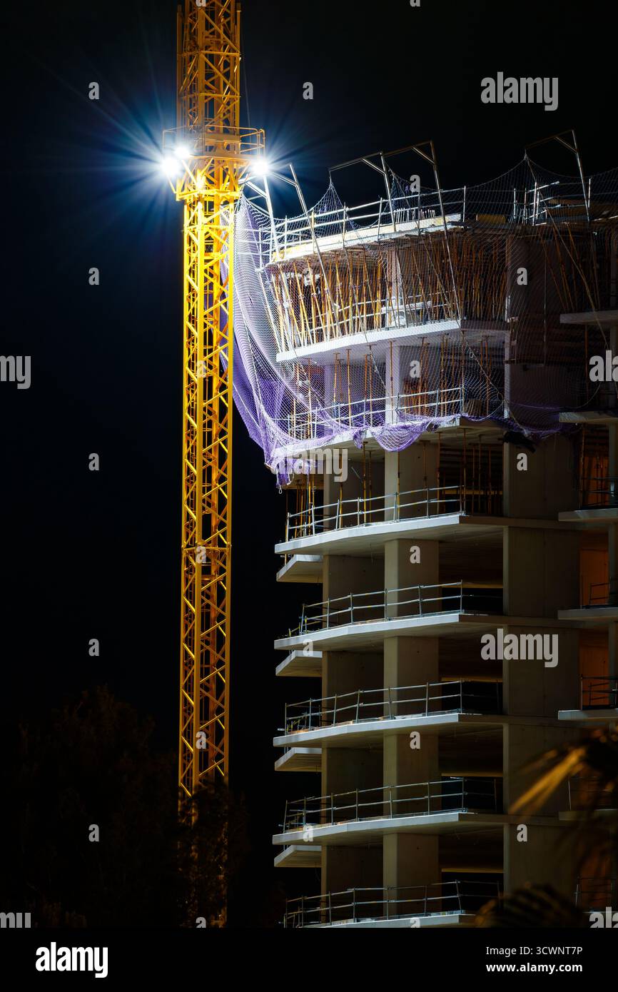 Gru da costruzione sagomata contro la notte Foto Stock