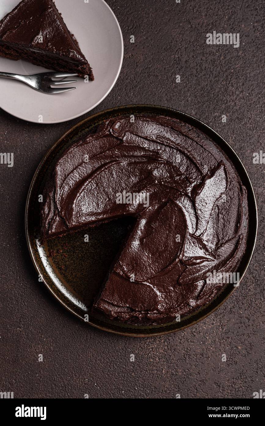 Torta brownie al cioccolato con ricca guarnizione di cioccolato, vista dall'alto. Un pezzo di torta al cioccolato doppio. Foto Stock