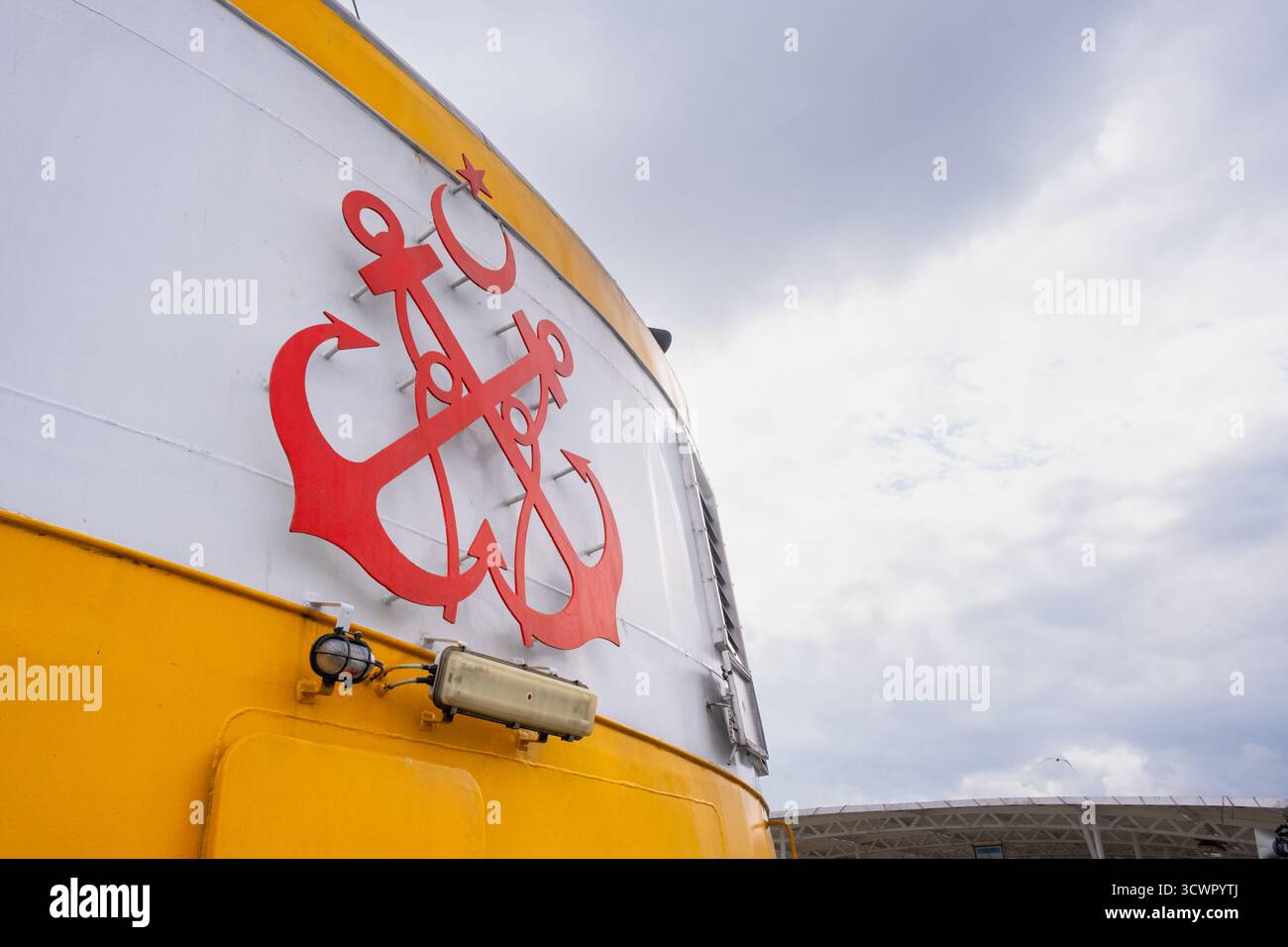 Istanbul, Turchia - 23 maggio 2023: Logo Sehir Hatlari sul traghetto. Logo dell'ancora rossa su una barca gialla e bianca contro il cielo blu. Logo simbolo Sehir Hatlari Foto Stock