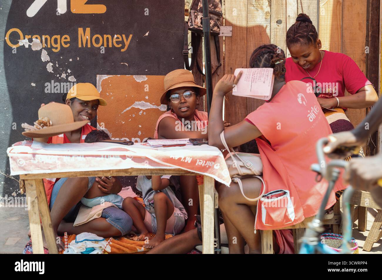 Miandrivazo, Madagascar - 11 ottobre 2025: Gruppo di donne che gestiscono un punto di servizi finanziari mobili, utilizzando la tecnologia nel locale Miandrivazo Foto Stock