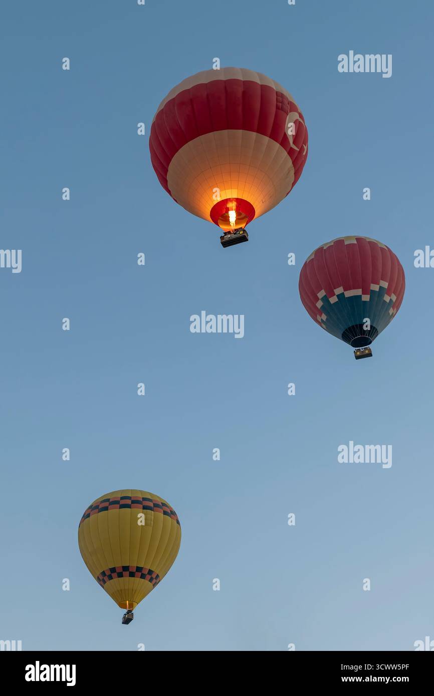 Tre mongolfiere volano contro il cielo blu a Pamukkale, Türkiye Foto Stock