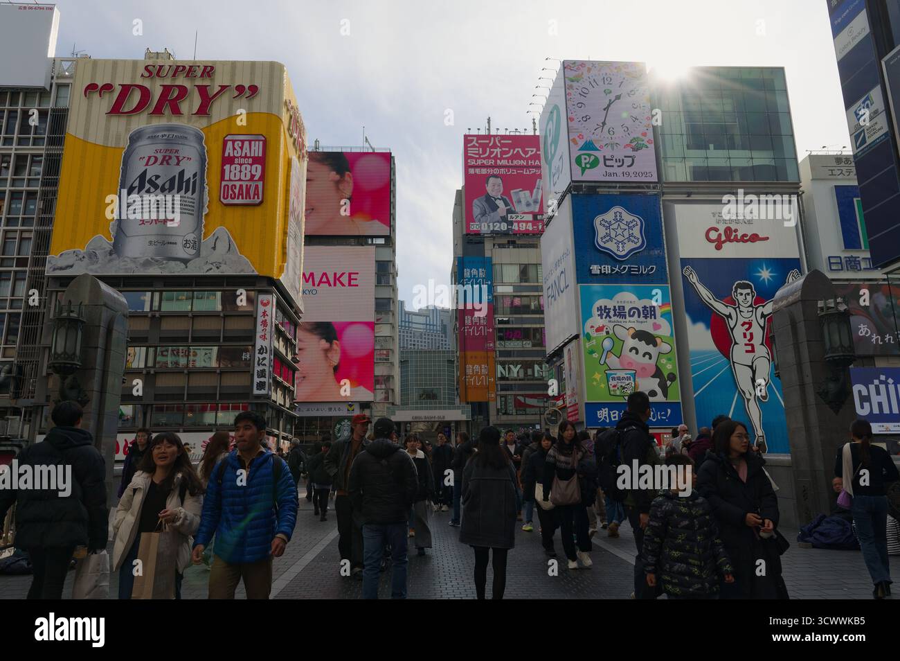 I pedoni camminano attraverso il vivace quartiere Dotonbori di Osaka Foto Stock