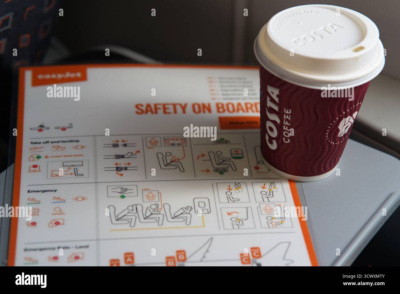Tazza di caffè Costa inserita su una carta di sicurezza easyJet a bordo, che mostra lo stile di vita a bordo e i dettagli del viaggio.Monaco, Germania Foto Stock