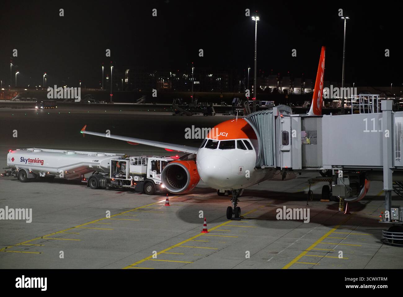 Aereo easyJet al cancello dell'aeroporto di Monaco durante il rifornimento notturno e la manutenzione sotto i riflettori luminosi.Monaco, Germania Foto Stock