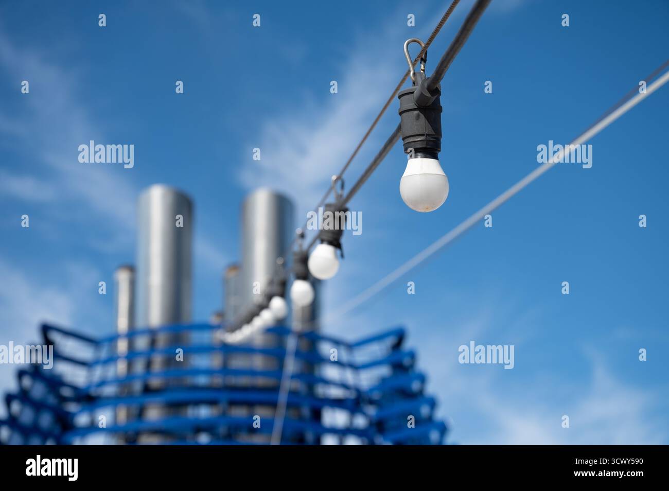 Luci a corda che conducono all'imbuto della nave da crociera contro il cielo blu. Messa a fuoco selettiva. Foto Stock