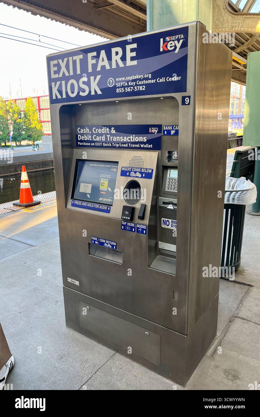 Un chiosco argentato con un cartello blu che dice Exit fare Kiosk. Il chiosco si trova su un marciapiede vicino a un bidone della spazzatura, Spring Garden Station, Philadelphia, U Foto Stock Un chiosco argentato con un cartello blu che dice Exit fare Kiosk. Il chiosco si trova su un marciapiede vicino a un bidone della spazzatura, Spring Garden Station, Philadelphia, U Foto Stock