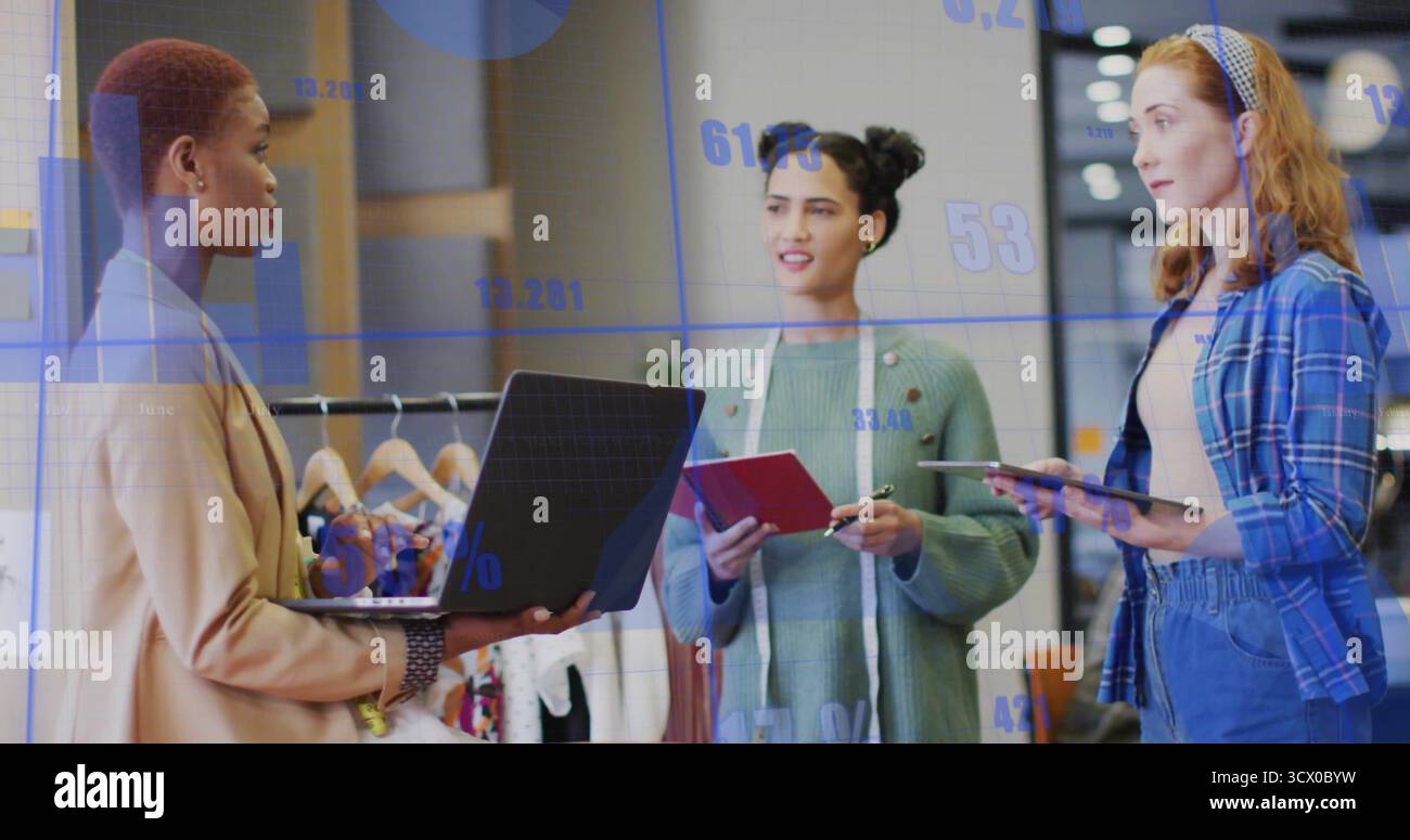 Discutere di tre professionisti che esaminano le tabelle dati in studio, con un metro a nastro per laptop Foto Stock