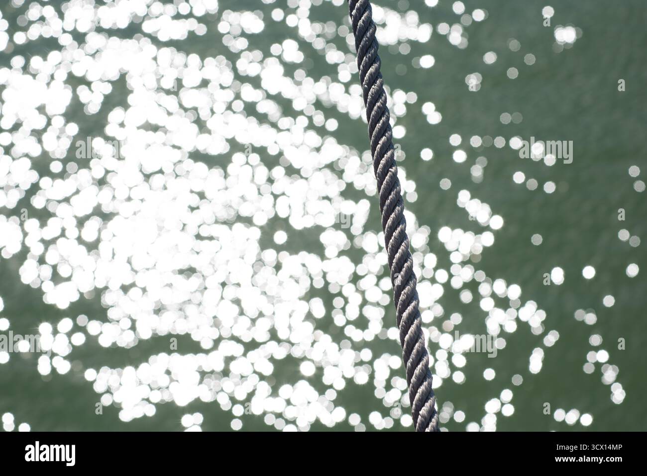 Una linea di ormeggio sull'acqua con un forte effetto bokeh. Foto Stock