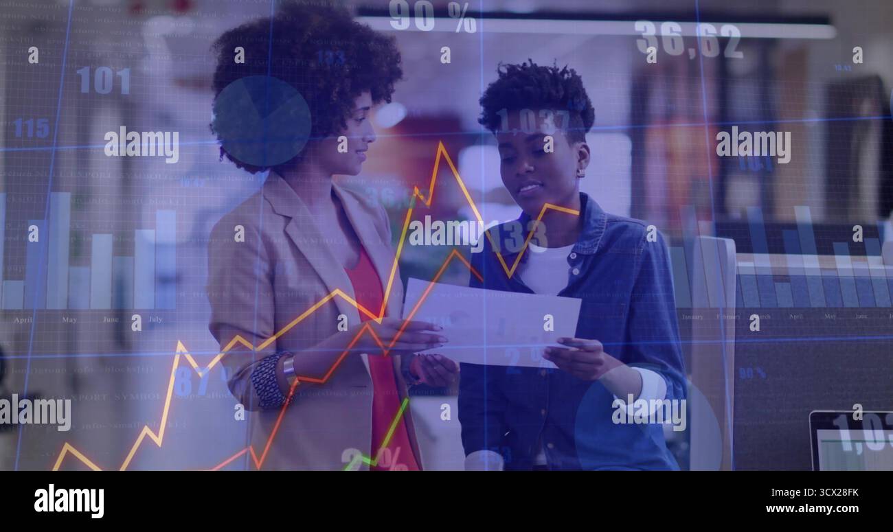 Esaminando i colleghi che indossano un blazer e una camicia in denim nella sala dell'ufficio, con un computer portatile Foto Stock
